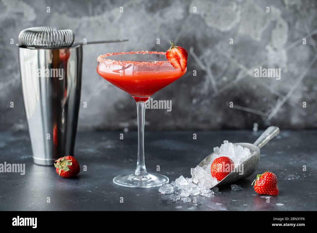 Cocktail di fragole con ghiaccio. Attrezzi da bar per la preparazione di bevande e agitatore Foto Stock