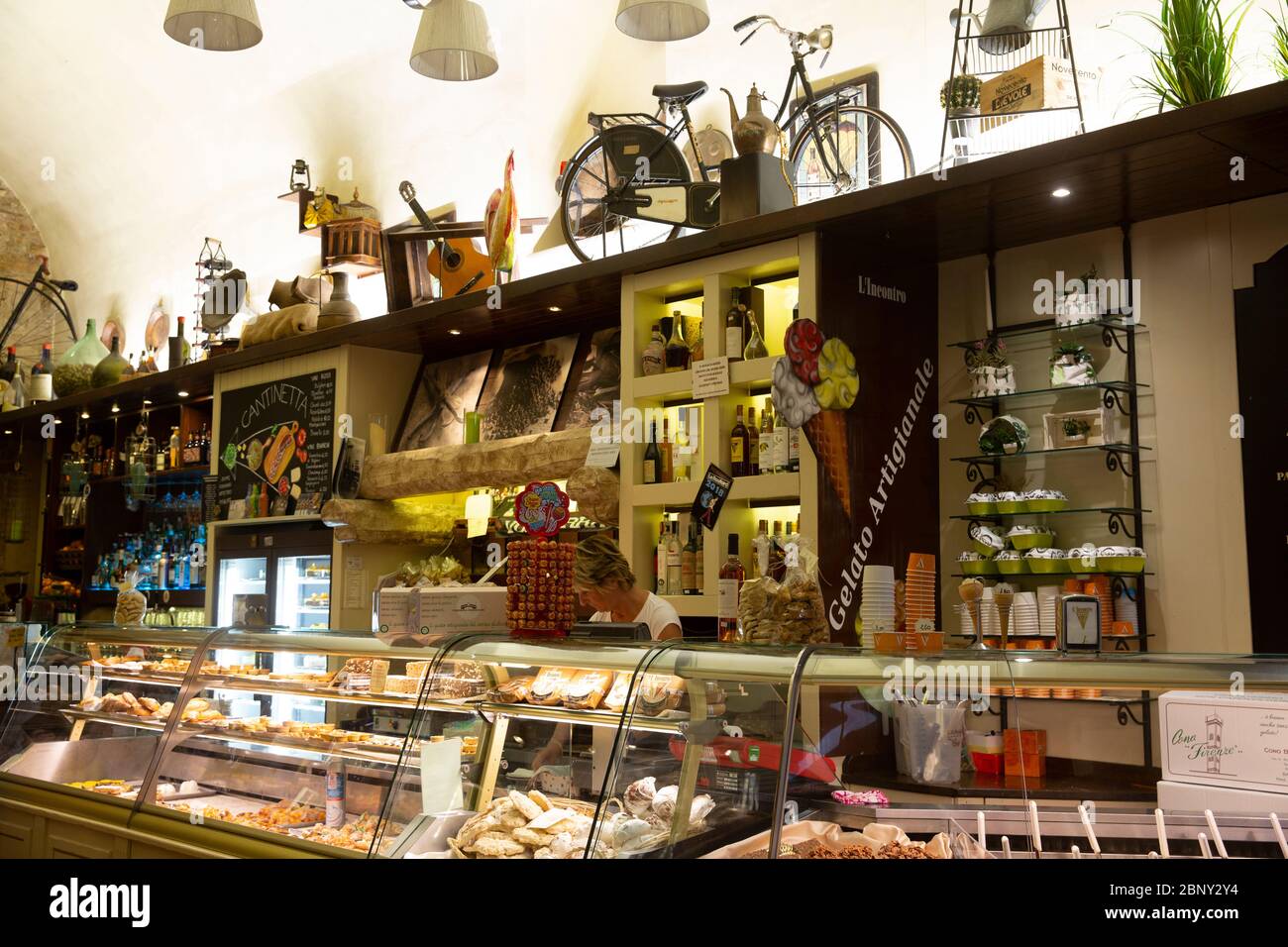 Tradizionale caffè italiano interno nella città medievale di Volterra con gelato e torta in essere servita, Toscana, Italia Foto Stock