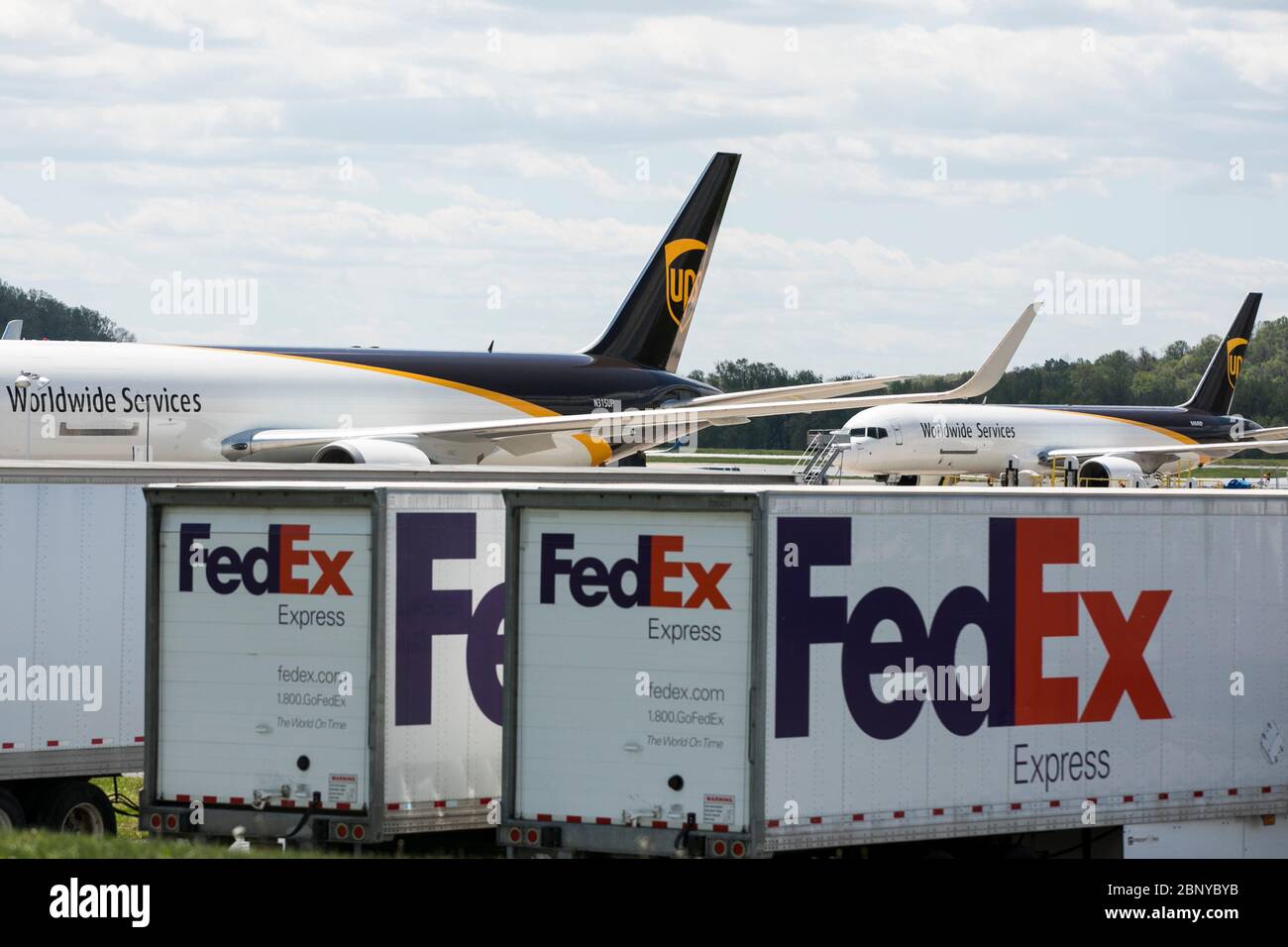 I rimorchi FedEx Express Truck sono visti di fronte a un aeromobile UPS Airlines United Parcel Service a Middletown, Pennsylvania, il 4 maggio 2020. Foto Stock