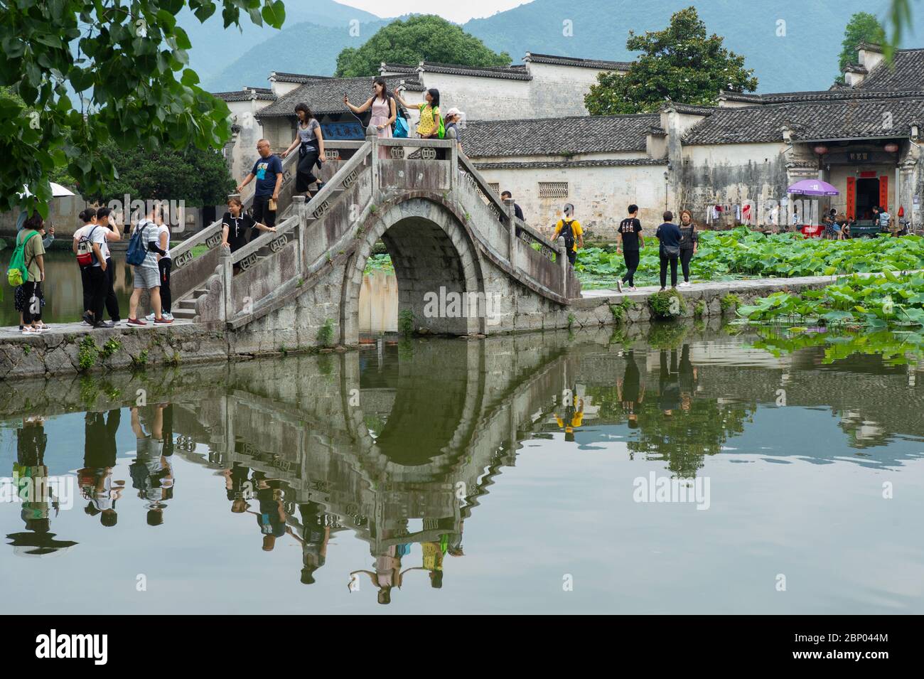 I turisti si fermano per scattare selfie sul ponte Hua nel villaggio di Hongcun, Cina. Foto Stock