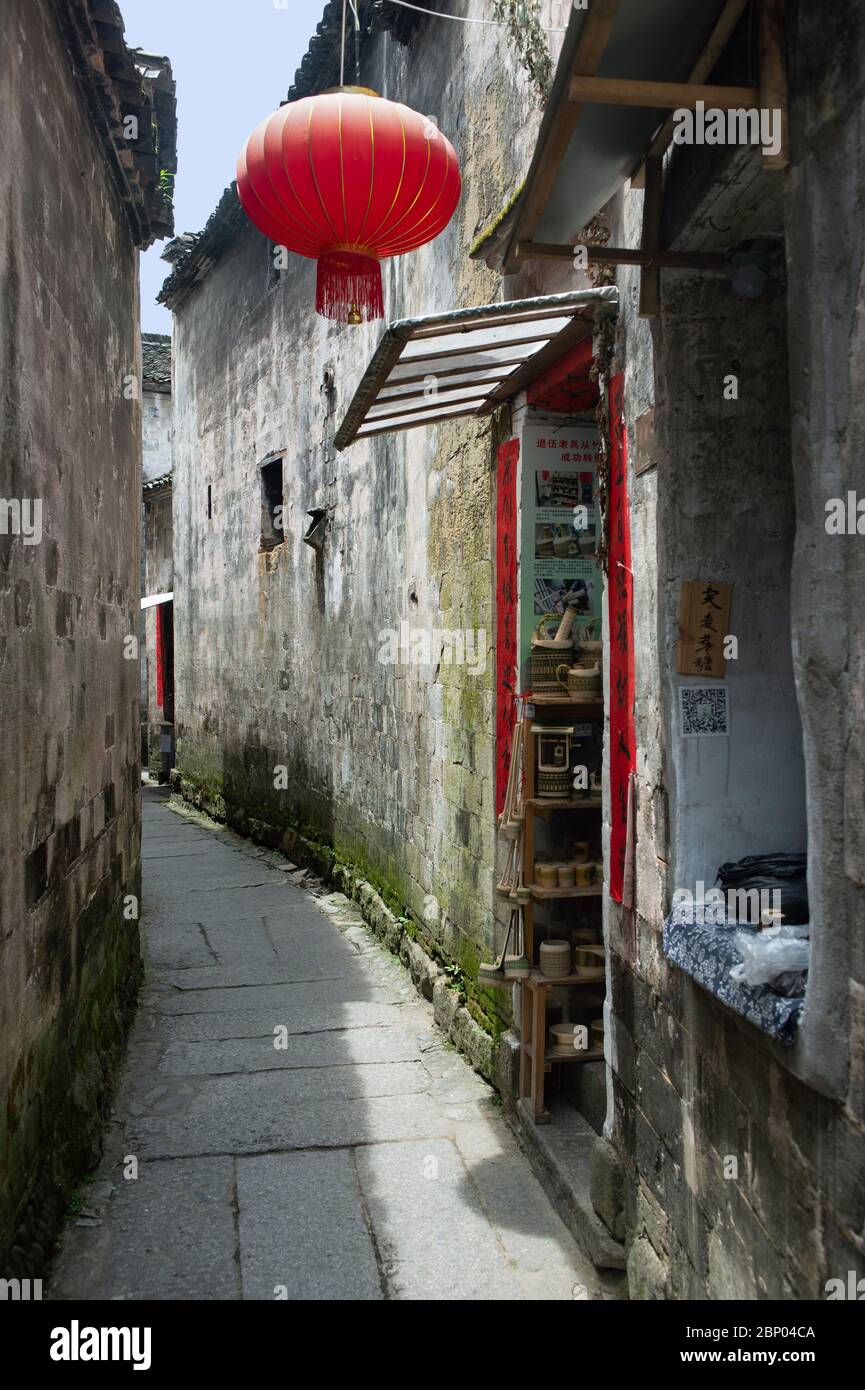 Una lanterna cinese rossa è appesa fuori da un piccolo negozio di vicoli  nell'antica città di Hongcun in Cina Foto stock - Alamy