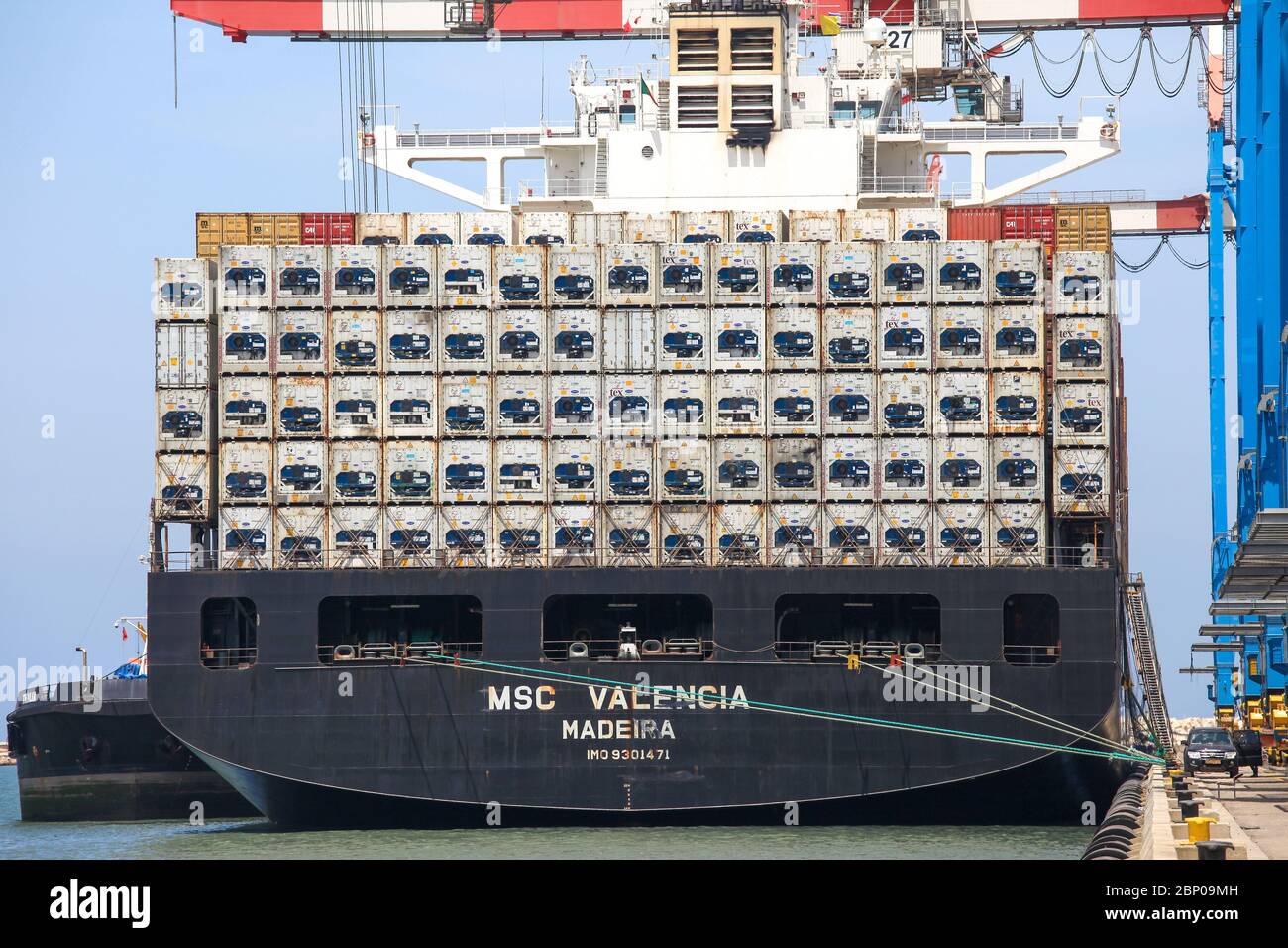 Contenitore grande spedire ancorato a un porto commerciale durante il caricamento e scarico Foto Stock