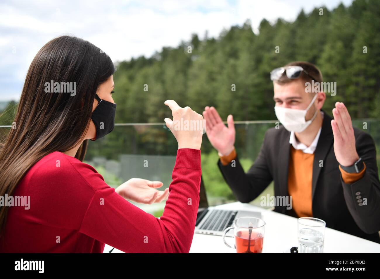 coppia con maschera medica protettiva con pausa caffè in un ristorante, nuovo concetto normale di coronavirus Foto Stock