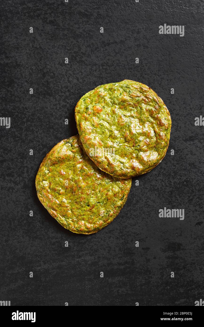 Base di pizza di crosta vegetale sana su sfondo di pietra scura con spazio libero per il testo. Vista dall'alto, disposizione piatta Foto Stock