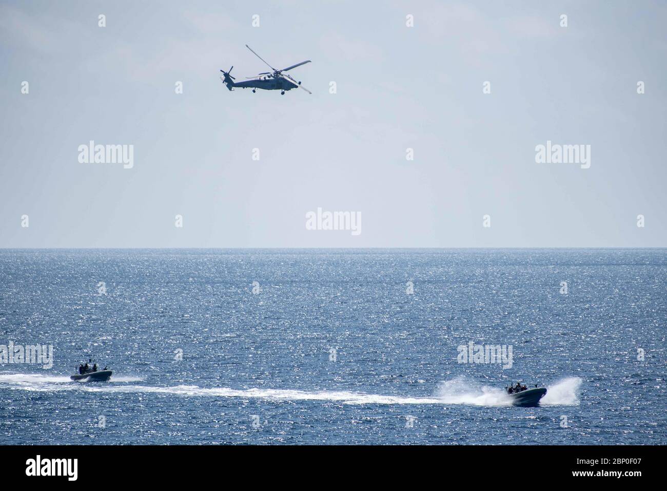 200426-N-OQ778-1023 GOLFO DI ADEN (26 aprile 2020) un falco marino MH-60R, attaccato alle "Swamp Foxes" dell'Helicopter Maritime Strike Squadron 74, e due imbarcazioni gonfiabili a scafo rigido attaccate al cacciatorpediniere missilistico guidato USS Truxtun (DDG 103) effettuano operazioni di routine il 26 aprile 2020. Truxtun è dispiegato nella 5° area di attività della flotta degli Stati Uniti a sostegno delle operazioni navali per garantire la stabilità e la sicurezza marittima nella regione centrale, collegando il Mediterraneo e il Pacifico attraverso l'Oceano Indiano Occidentale e tre punti di strozzamento strategici. (STATI UNITI Foto Navy di Mass Communication Specialist Foto Stock