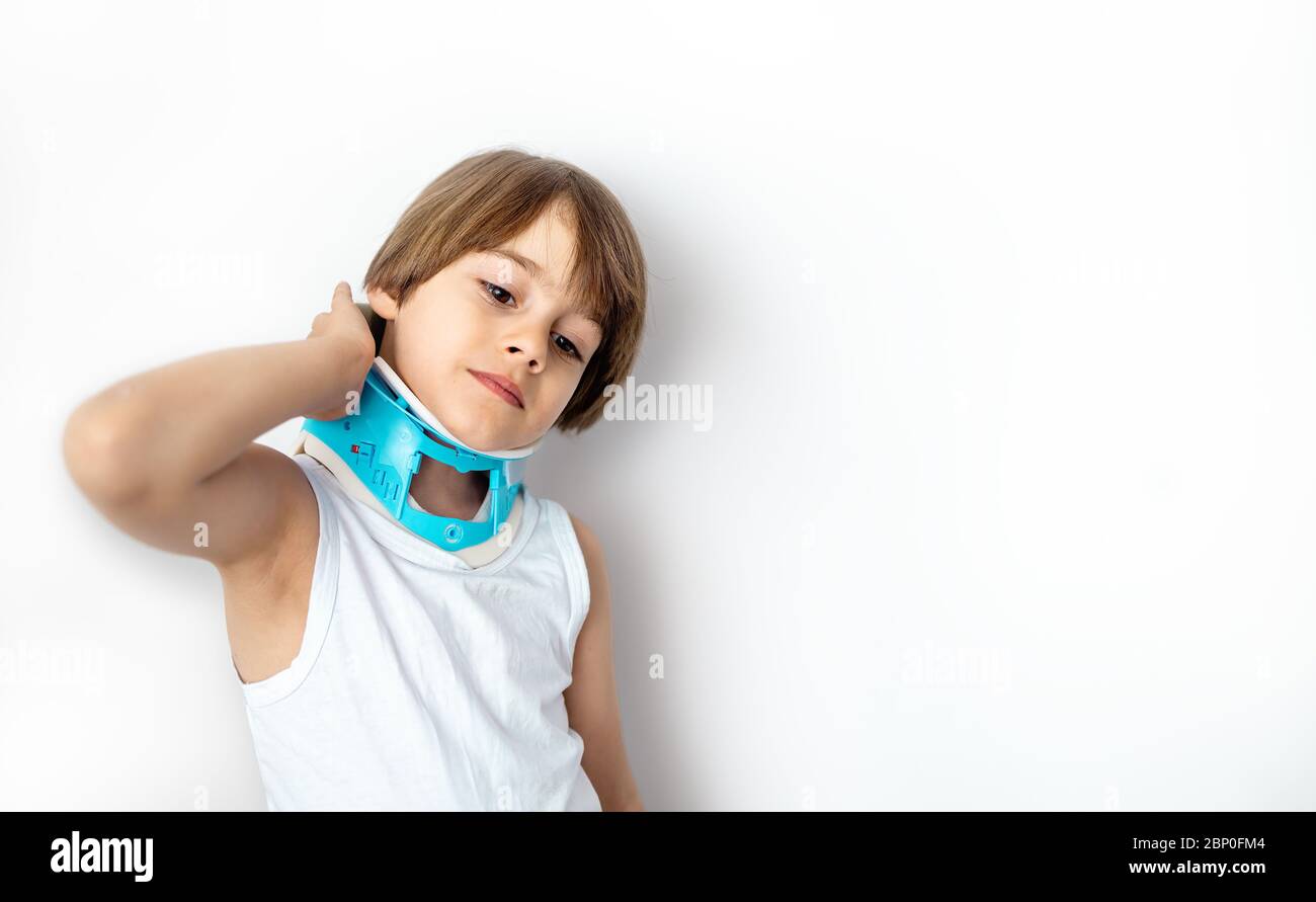Bambino lamenta dolore al collo indossando un supporto cervicale del collare. Sfondo bianco Foto Stock
