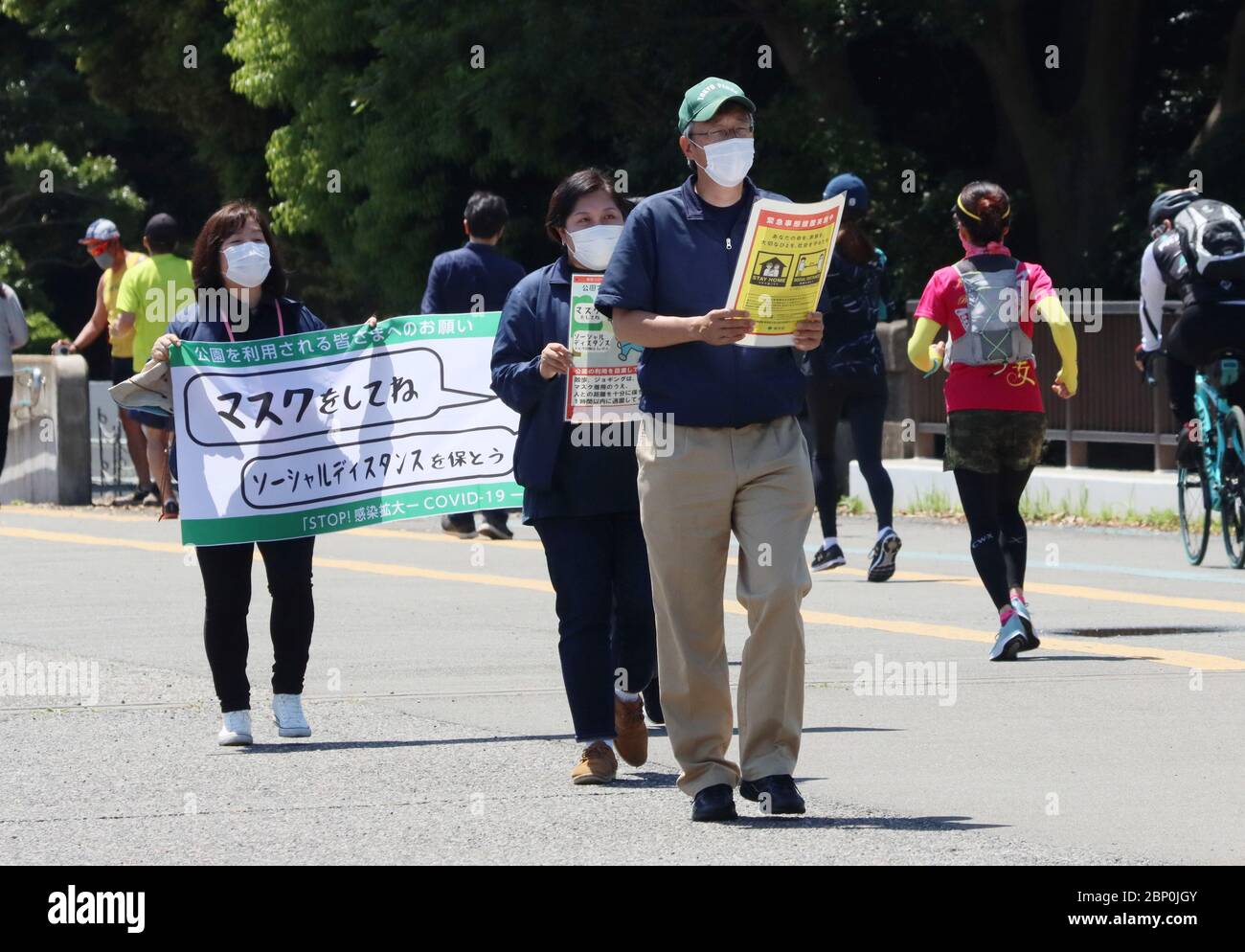 Tokyo, Giappone. 17 maggio 2020. I funzionari del parco hanno un banner e un cartello per mantenere la distanza sociale da joggers in un parco a Tokyo domenica 17 maggio 2020. Il governo giapponese ha esteso lo stato di emergenza per l'area metropolitana di Tokyo il 14 maggio. Credit: Yoshio Tsunoda/AFLO/Alamy Live News Foto Stock