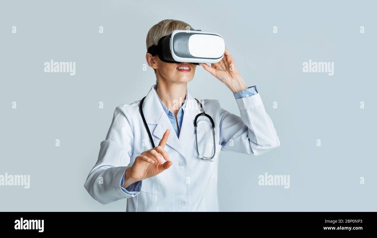 Formazione virtuale per i medici. Donna medico in realtà virtuale occhiali punta dito Foto Stock