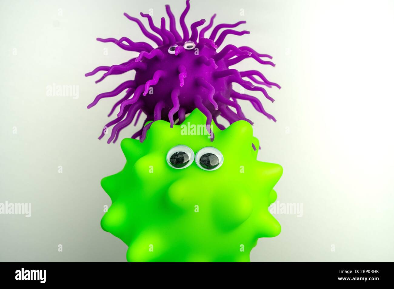 Due giocattoli colorati con gli occhi come rappresentazione di virus o batteri Foto Stock