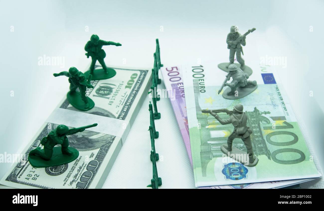 Miniatura plastica figura di soldati in cima a due fasci, uno fatto di dollari di bollette e l'altro di euro con un fossato di plastica nel mezzo Foto Stock