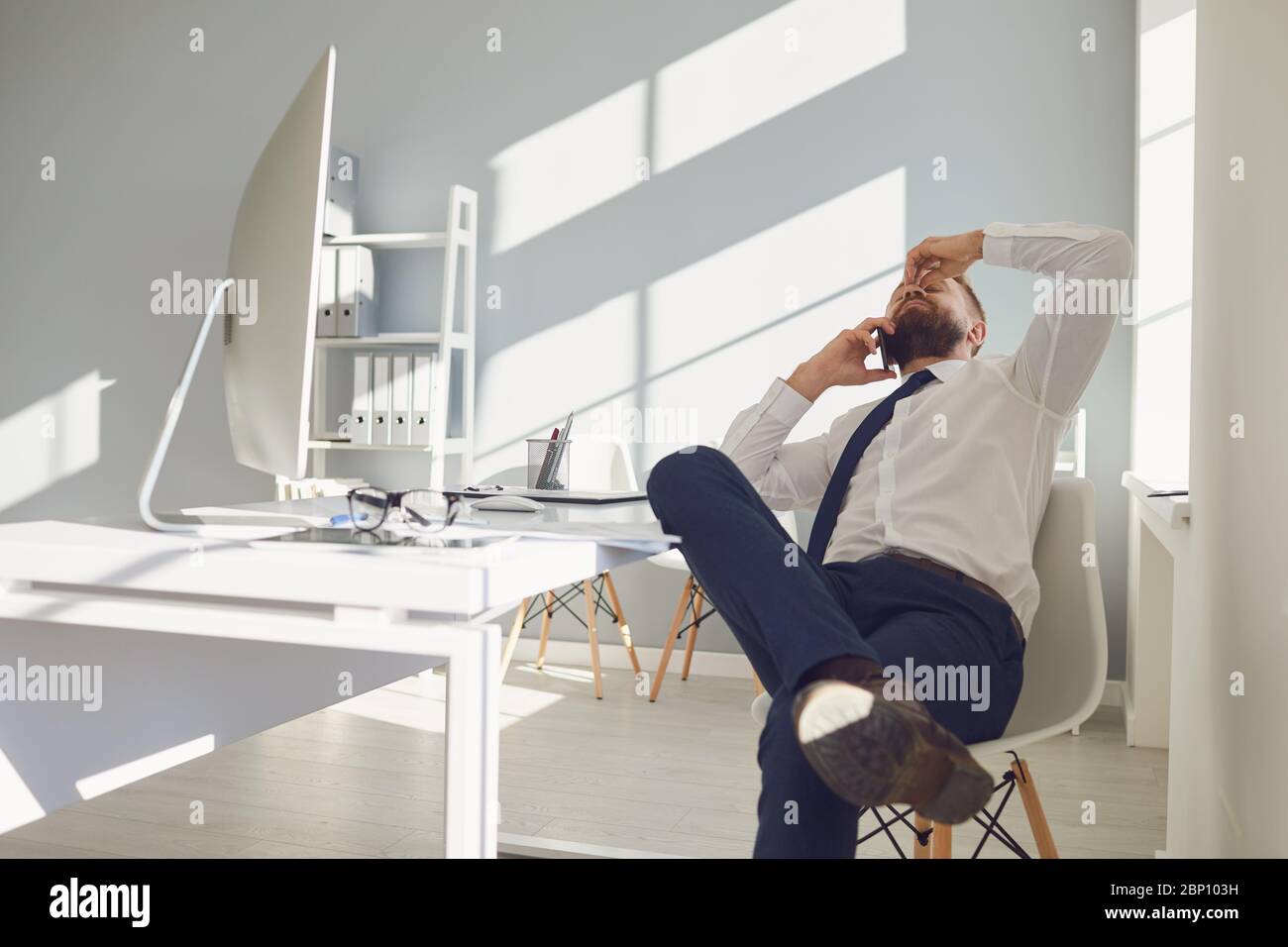 Molto lavoro in ufficio. Stanco uomo d'affari occupato sta lavorando con il computer Foto Stock