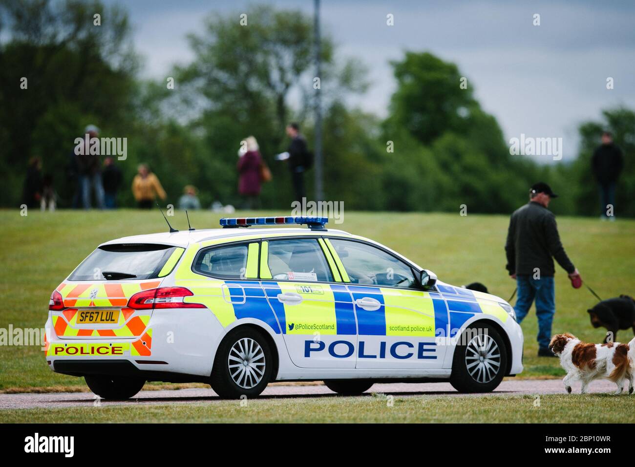 Auto di polizia in pattuglia a Glasgow Green, durante il blocco pandemico Coronavirus, come le persone si esercitano quotidianamente. Foto Stock