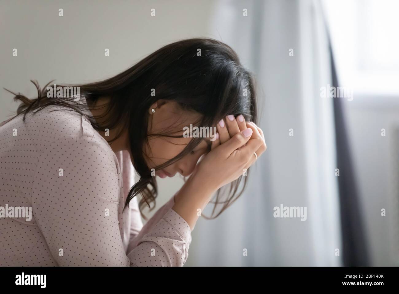 La donna africana copre il viso con le mani sembra disperata e infelice Foto Stock