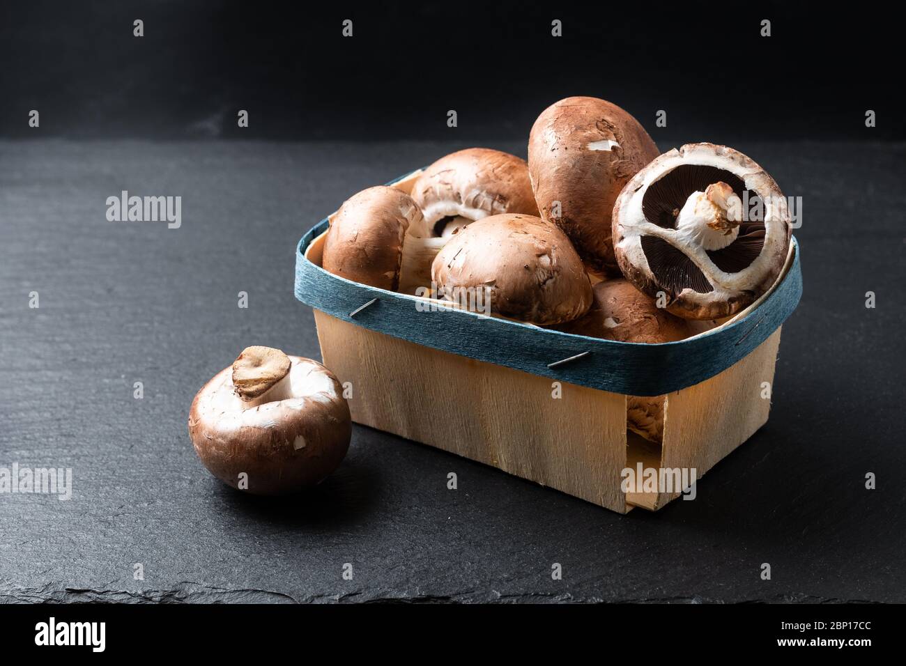 Helathy food concept Organic Cremini funghi marrone su sfondo nero di ardesia con spazio per la copia Foto Stock