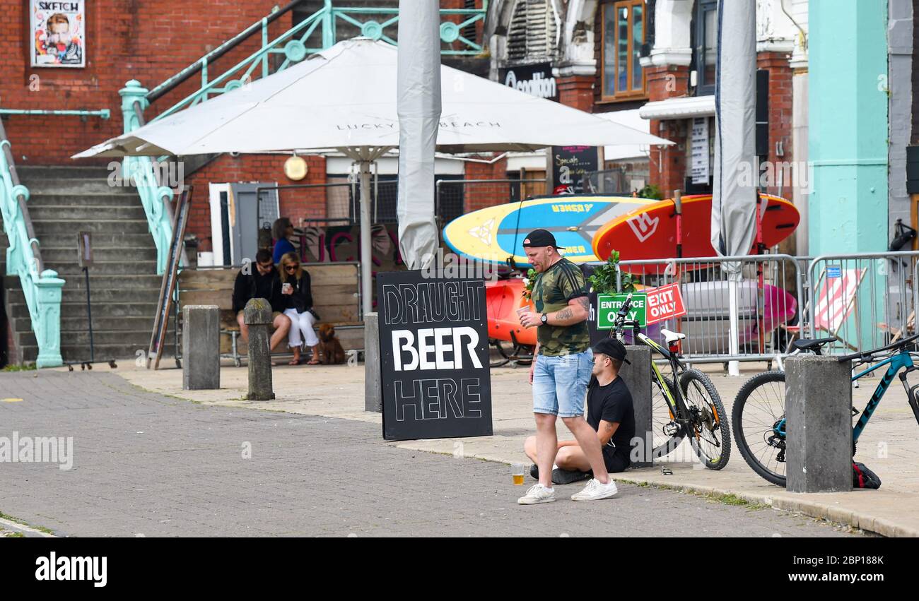 Brighton UK 17 maggio 2020 - si poteva prendere birre lungo il lungomare di Brighton, che era piuttosto tranquilla a pranzo oggi in una giornata calda con un mix di sole e nuvole il primo fine settimana dopo i governi leggermente alleggerimento delle restrizioni di blocco in Inghilterra durante il coronavirus COVID-19 pandemia . Credit: Simon Dack / Alamy Live News Foto Stock