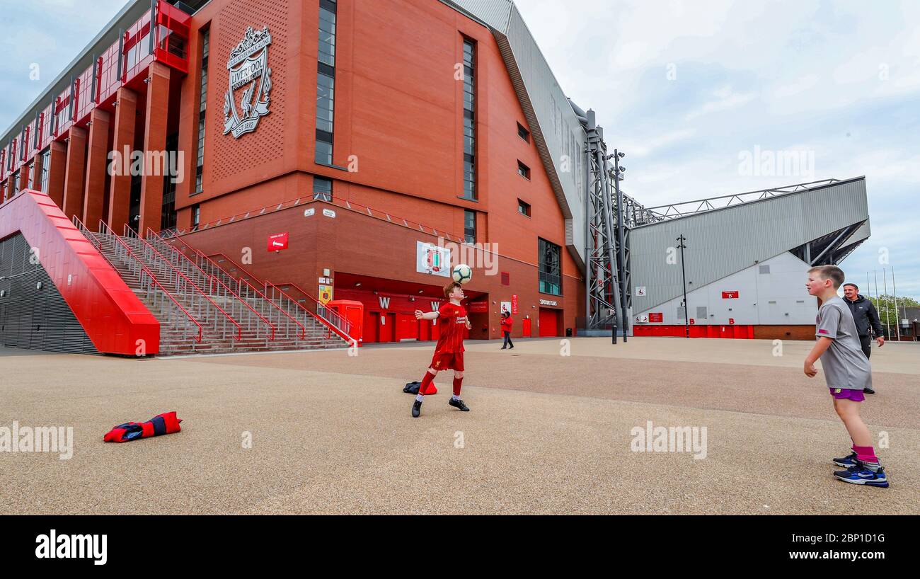 James Ryan-Byrne 9 anni (kit rosso) e Ethan Potsig 9 anni giocano a calcio fuori Anfield - sede dei top da tavolo della Premiership Liverpool. Oggi, Liverpool avrebbe dovuto disputare la loro partita finale del 19/20 Away a Newcastle a St James Park. Foto Stock