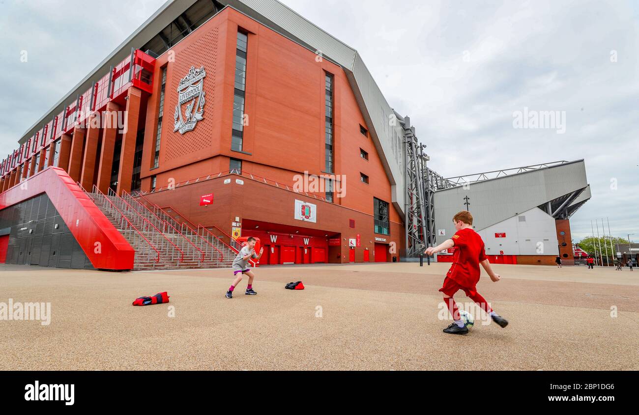 James Ryan-Byrne 9 anni (kit rosso) e Ethan Potsig 9 anni giocano a calcio fuori Anfield - sede dei top da tavolo della Premiership Liverpool. Oggi, Liverpool avrebbe dovuto disputare la loro partita finale del 19/20 Away a Newcastle a St James Park. Foto Stock