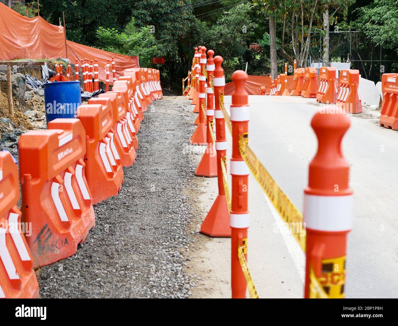 Medellin, Colombia, ottobre 20 2019: Barriere di costruzione arancione su una strada lavori con sentiero pedonale Foto Stock