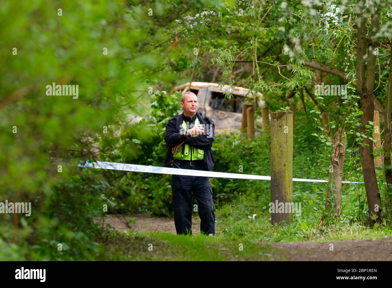 Una scena di ufficiale di crimine protegge un veicolo bruciato a Swillington, dove il conducente del veicolo schiantato fuggì dalla scena. Foto Stock