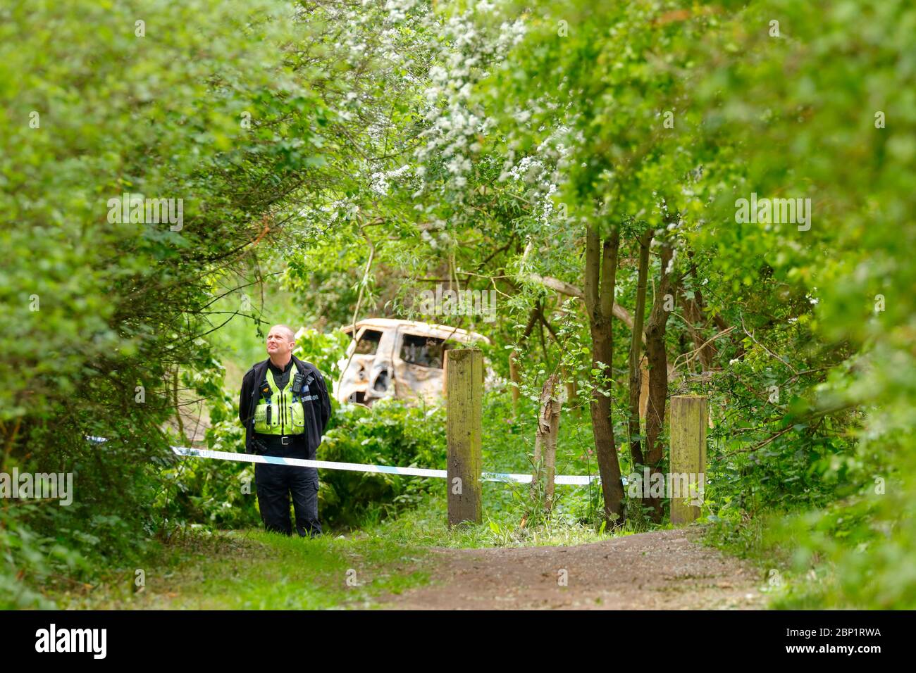 Una scena di ufficiale di crimine protegge un veicolo bruciato a Swillington, dove il conducente del veicolo schiantato fuggì dalla scena. Foto Stock