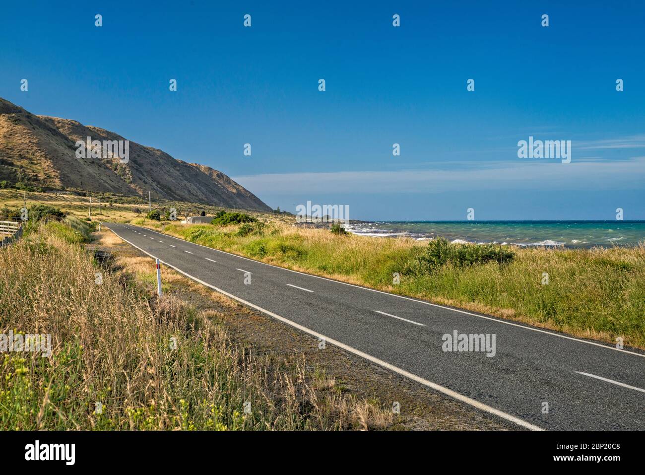 Cape Palliser Road vicino a te Humenga Point, Costa Sud di Wairarapa, Palliser Bay, Cook Strait, Regione di Wellington, Isola del Nord, Nuova Zelanda Foto Stock