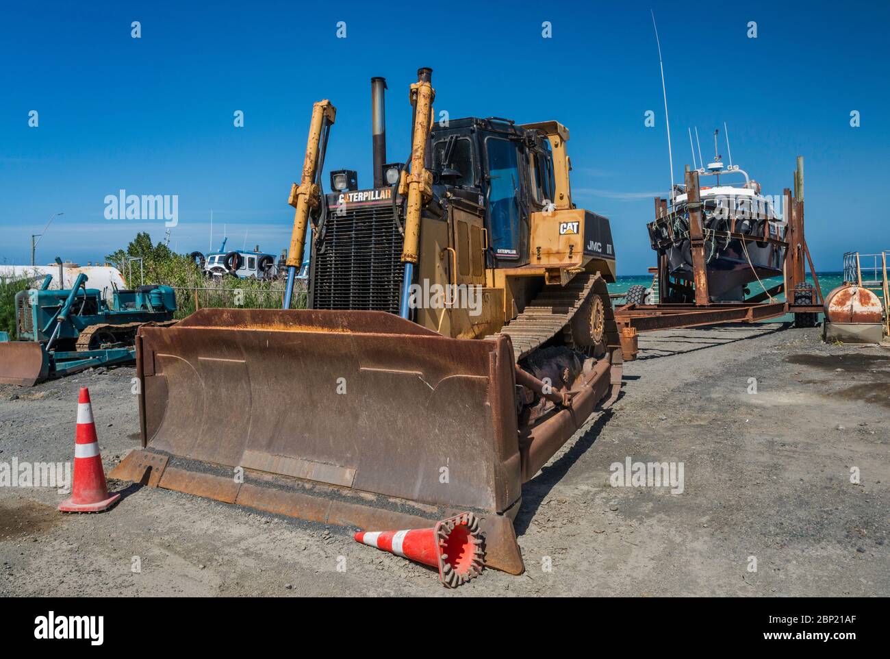 Bulldozer utilizzato per trascinare barche da pesca a riva, spiaggia nel villaggio di Ngawi, Wairarapa Coast, Wellington Regione, Isola del Nord, Nuova Zelanda Foto Stock