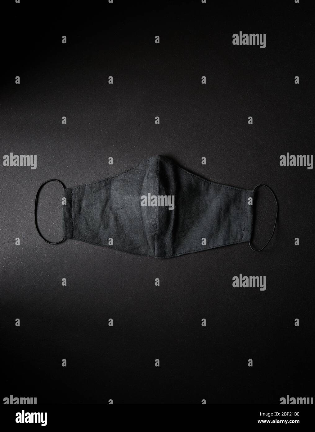 Maschera nera su fondo nero piatto. Maschera antinquinamento. Protezione da virus Corona e covid-91. Spazio libero per il testo Foto Stock