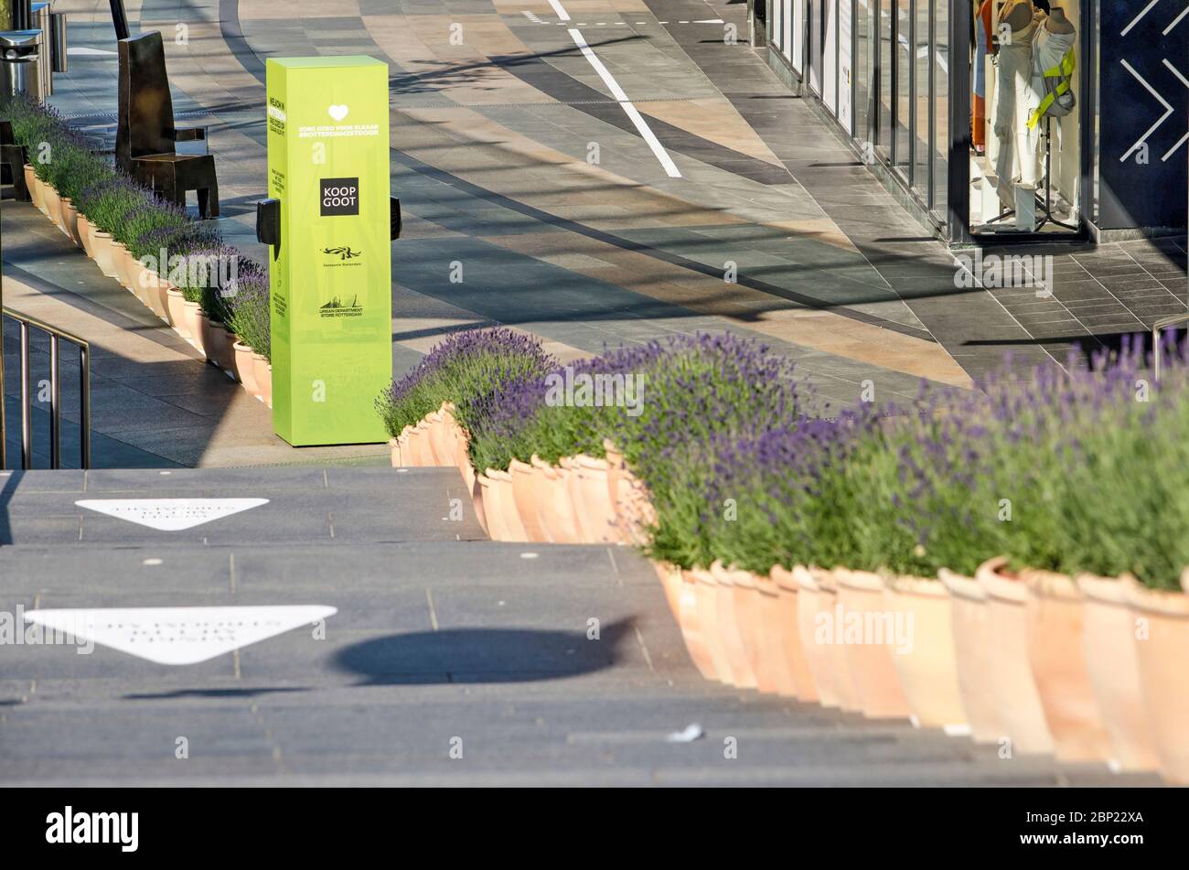 Rotterdam, Paesi Bassi, 17 maggio 2020: Scala che conduce alla via dello shopping Koopgoot con distributore di gel disinfettante e pentole di lavanda sepe Foto Stock