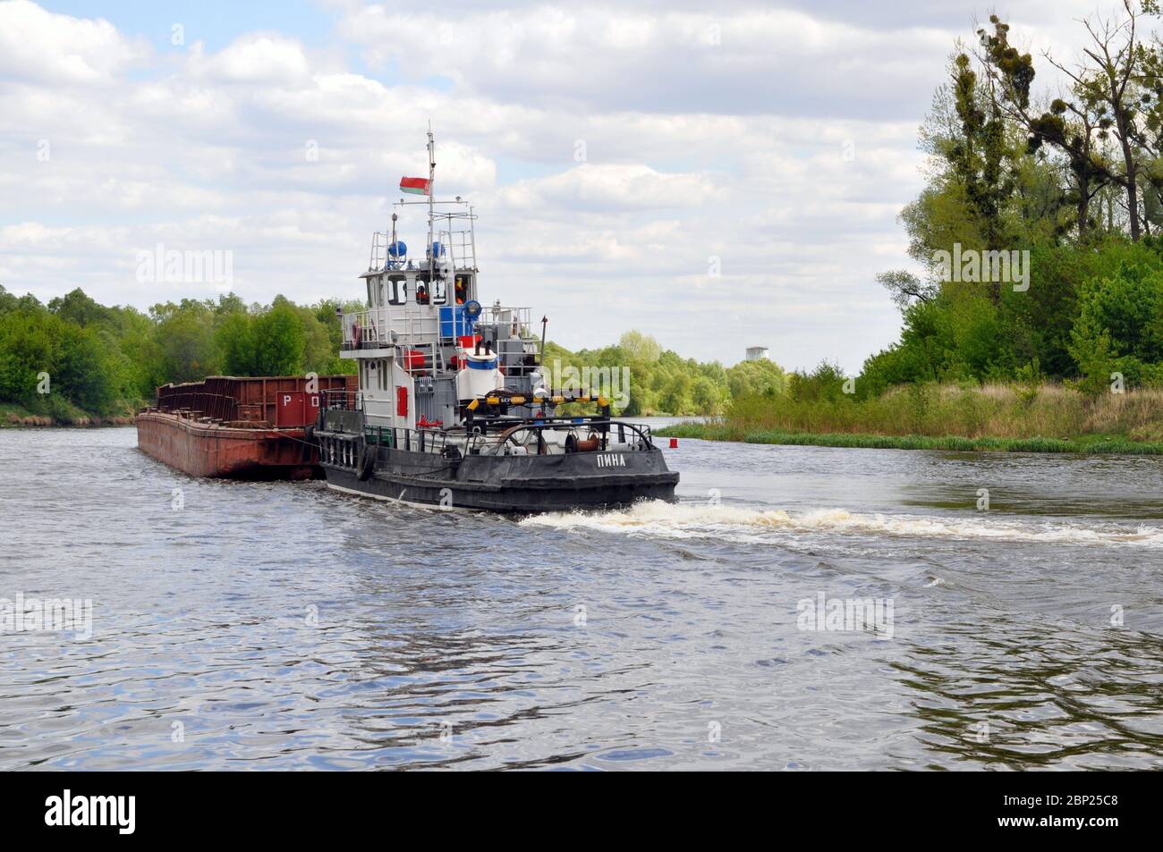Movimento di un rimorchiatore con chiatta lungo il fiume Pripyat. Foto Stock
