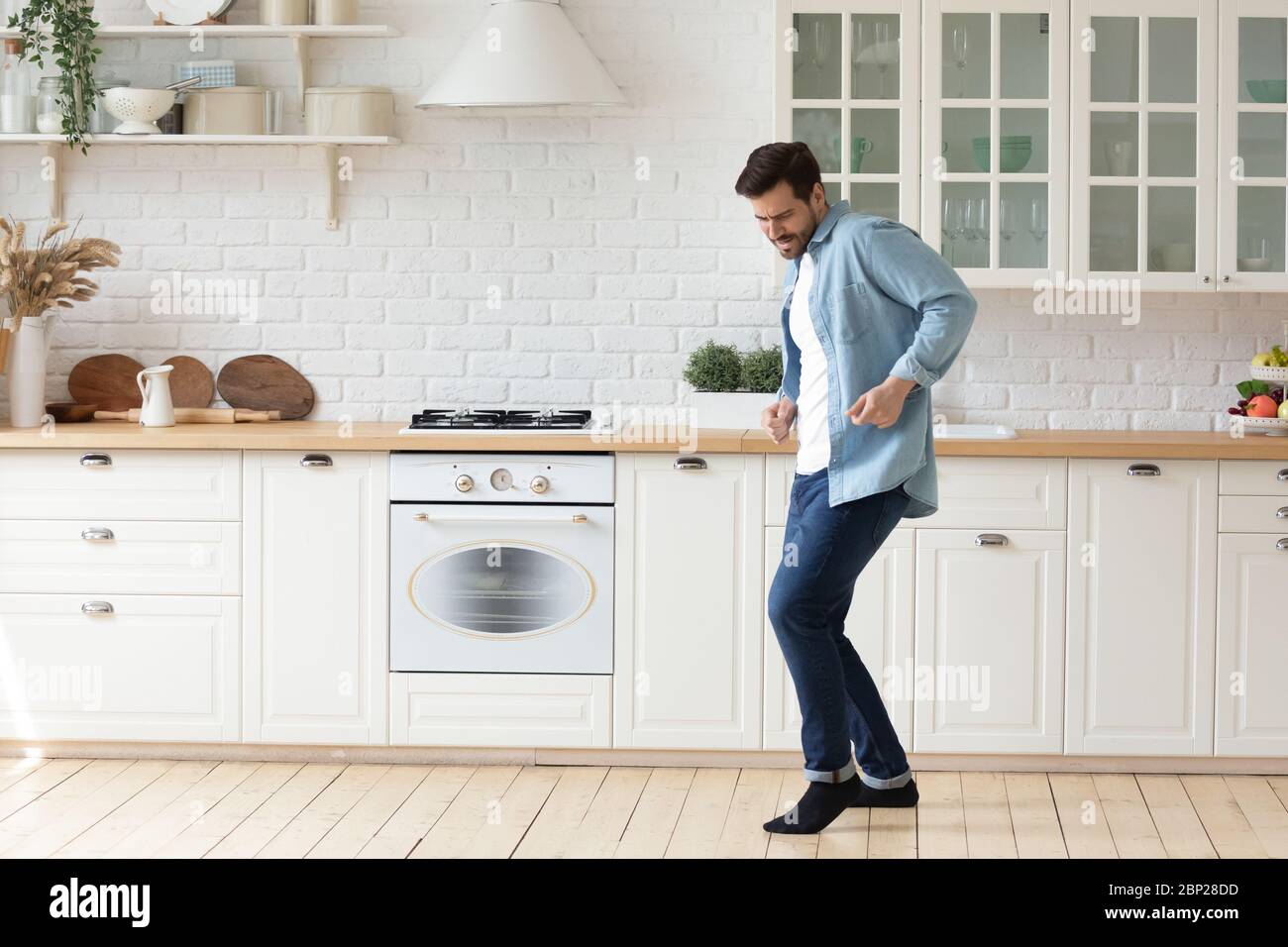 Felice giovane che balla in una cucina dal design moderno Foto Stock