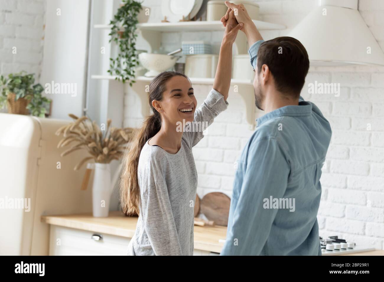 Felice giovane coppia che danzano in cucina moderna a casa Foto Stock
