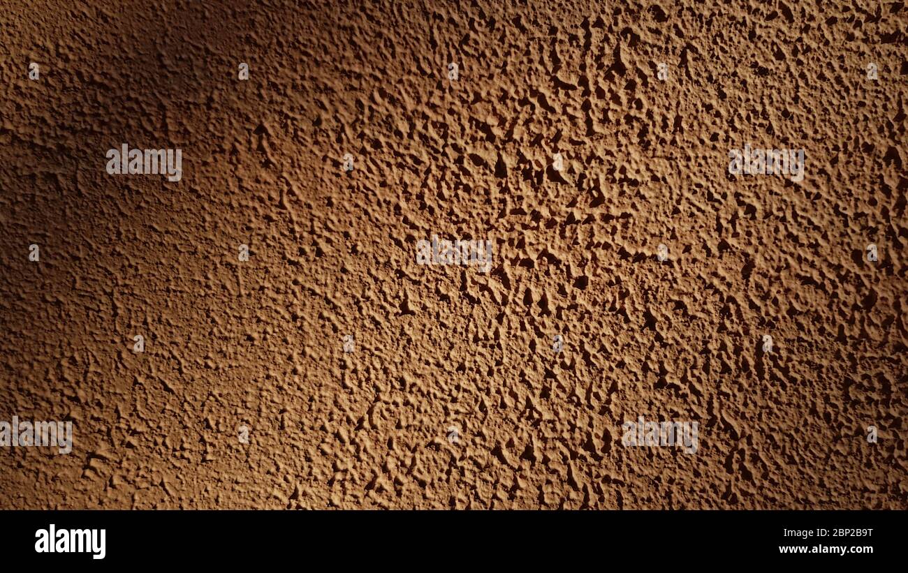 Stucco grezza intonaco parete texture closeup. Sfondo marrone testurizzato astratto con spazio di copia Foto Stock