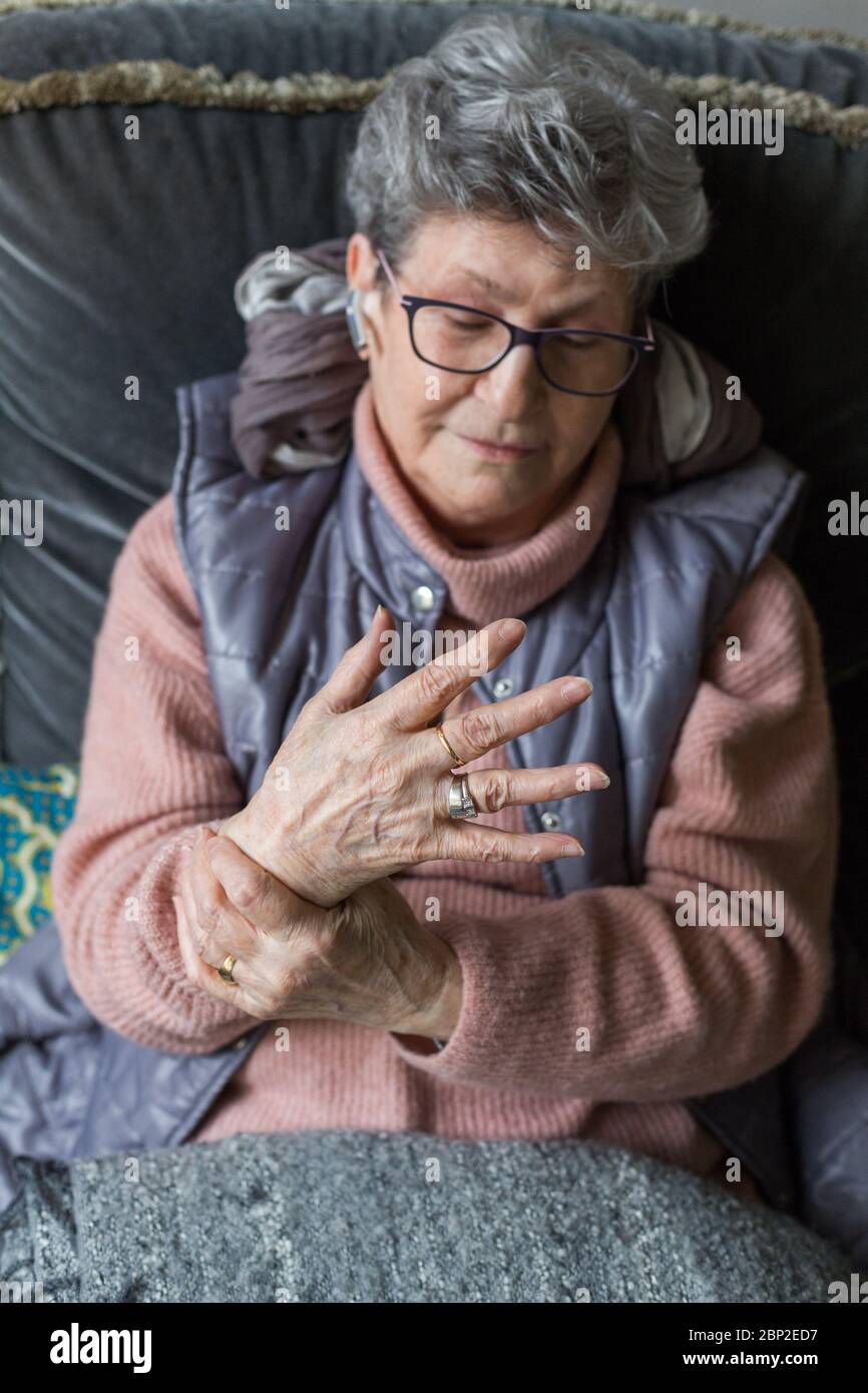 Senior donna che soffre di un dolore articolare in mano. Foto Stock