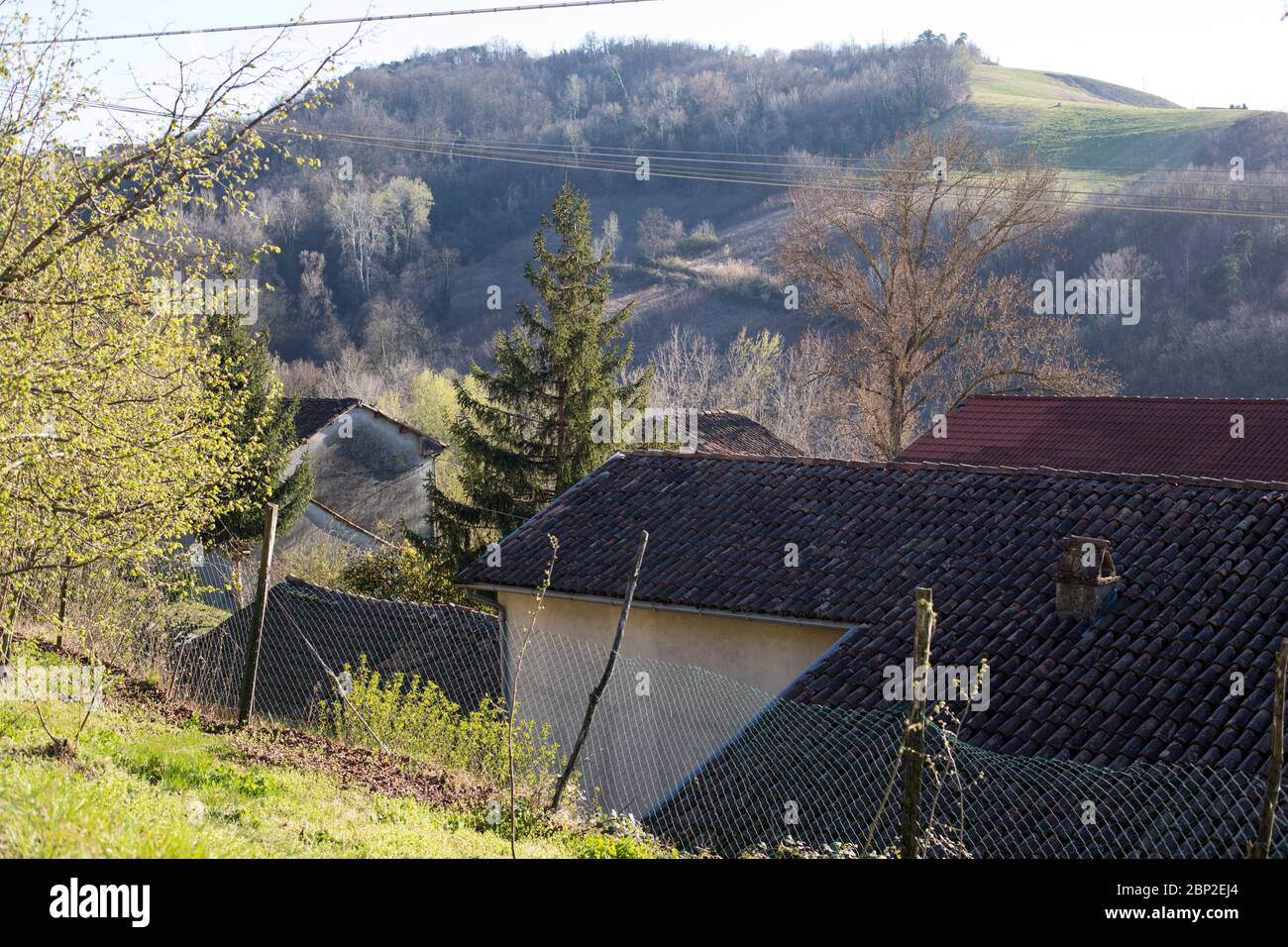Vista su case rurali con tetti rossi vicino Cassinasco in Piemonte, Italia settentrionale Foto Stock