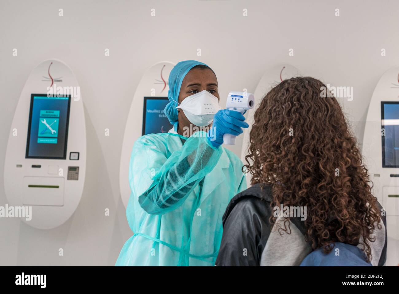 Misurazione della temperatura del paziente con un termometro per fronte alla reception del Cosem Atlas Medical Center, Parigi. Foto Stock