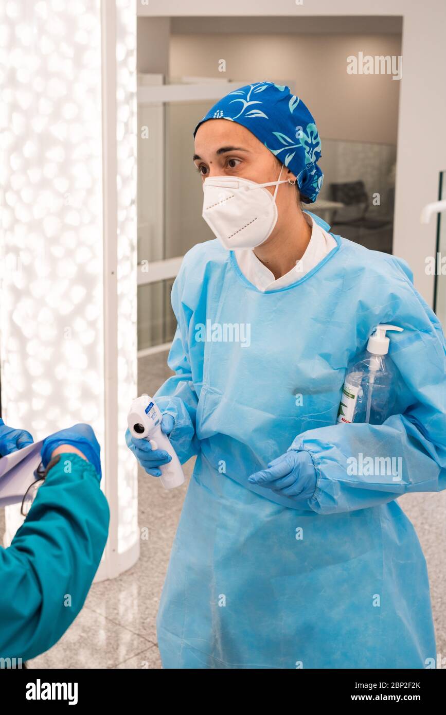 Misurazione della temperatura del paziente con un termometro per fronte alla reception del Cosem Atlas Medical Center, Parigi. Foto Stock