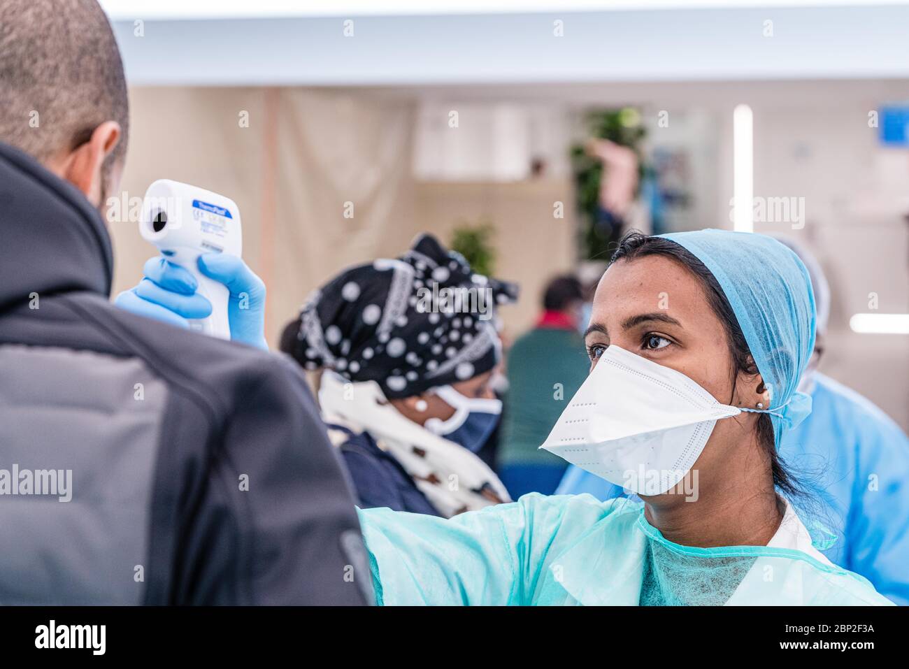 Misurazione della temperatura del paziente con un termometro per fronte alla reception del Cosem Atlas Medical Center, Parigi. Foto Stock