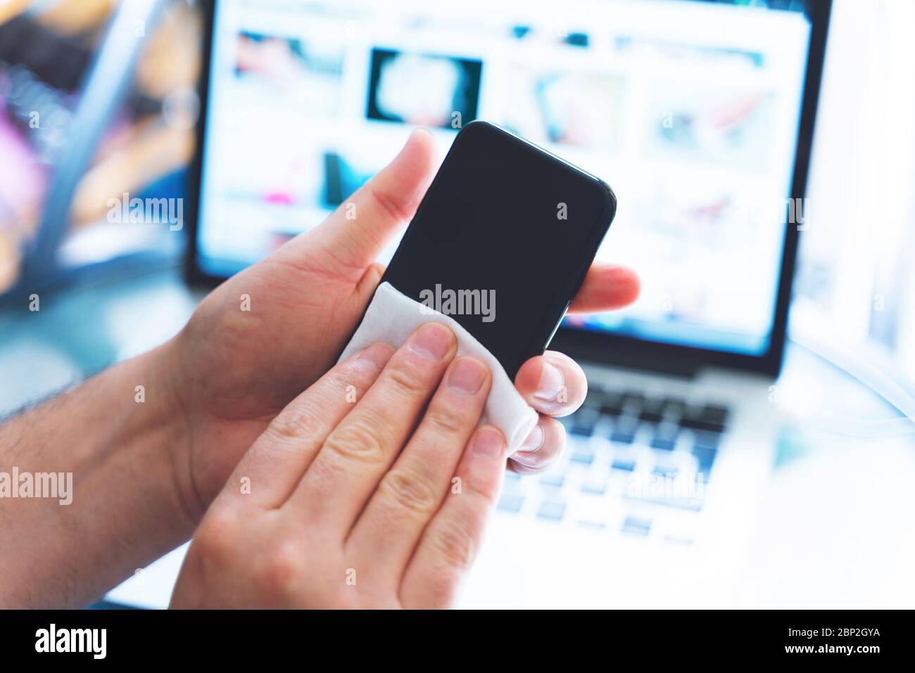 Pulizia dello schermo del telefono cellulare con salviette bagnate disinfettanti per smartphone pulizia pulizia preventiva per COVID-19 protezione da focolai di Coronavirus Foto Stock