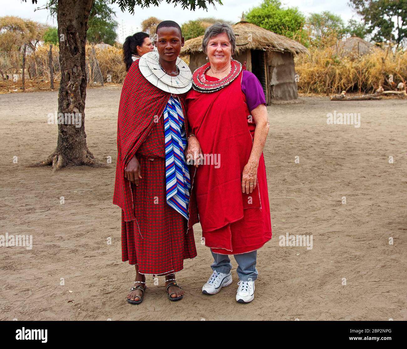 Villaggio Maasai, donna in visita, donna indigena; abito tradizionale, collari con perline a 2 strati, apprendimento, istruzione, Tanzania; Africa, MR Foto Stock