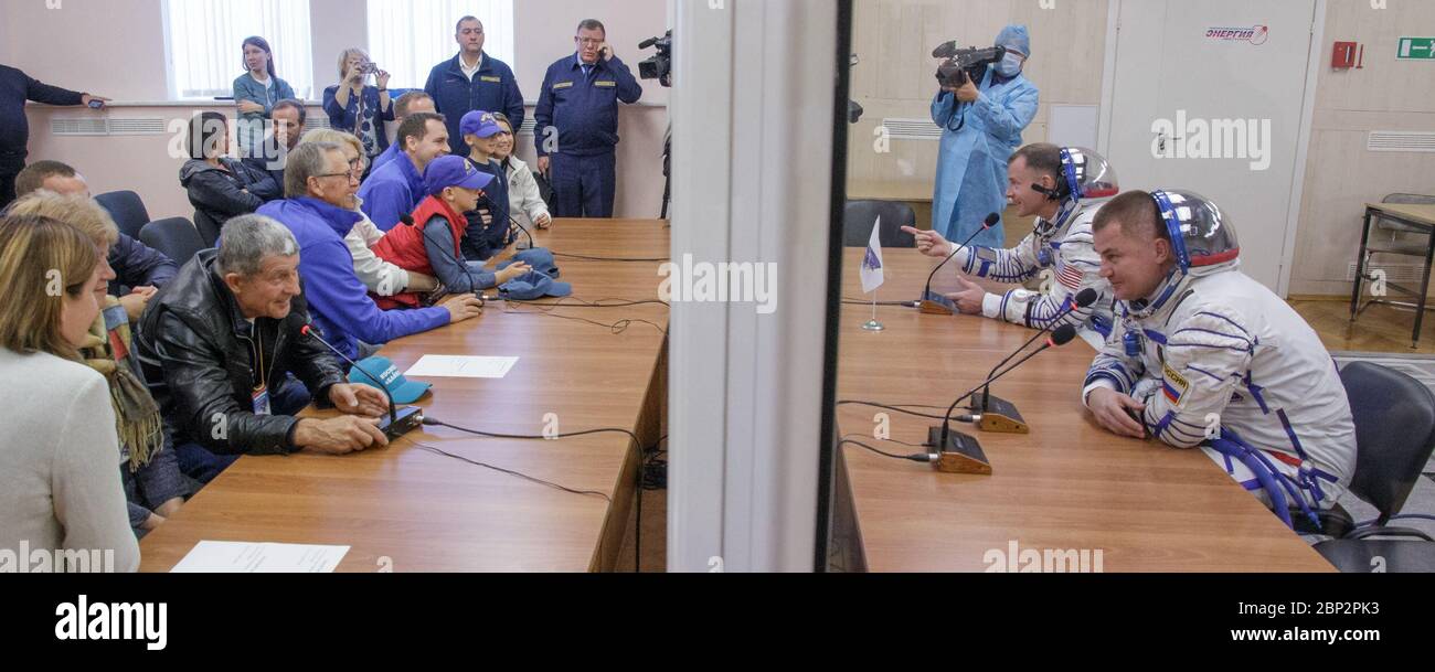 Expedition 57 Expedition 57 Flight Engineer Nick Hague della NASA, a sinistra, e l'ingegnere di volo Alexey Ovchinin di Roscosmos parlano con le loro famiglie dopo aver controllato la pressione delle loro tute Sokol per il loro lancio su un razzo Soyuz, giovedì 11 ottobre 2018 al Cosmodromo Baikonur in Kazakistan. Durante la salita in orbita della navicella spaziale Soyuz, si è verificata un'anomalia, che ha provocato un downrange di interruzione. L'equipaggio è stato rapidamente recuperato ed è in buone condizioni. Foto Stock