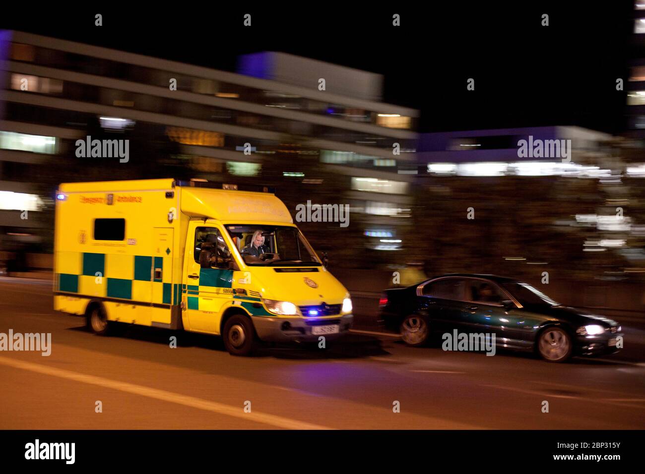 L'ambulanza di emergenza di Londra risponde di notte con luci blu e sfocatura del movimento a Londra, Inghilterra, Regno Unito Foto Stock