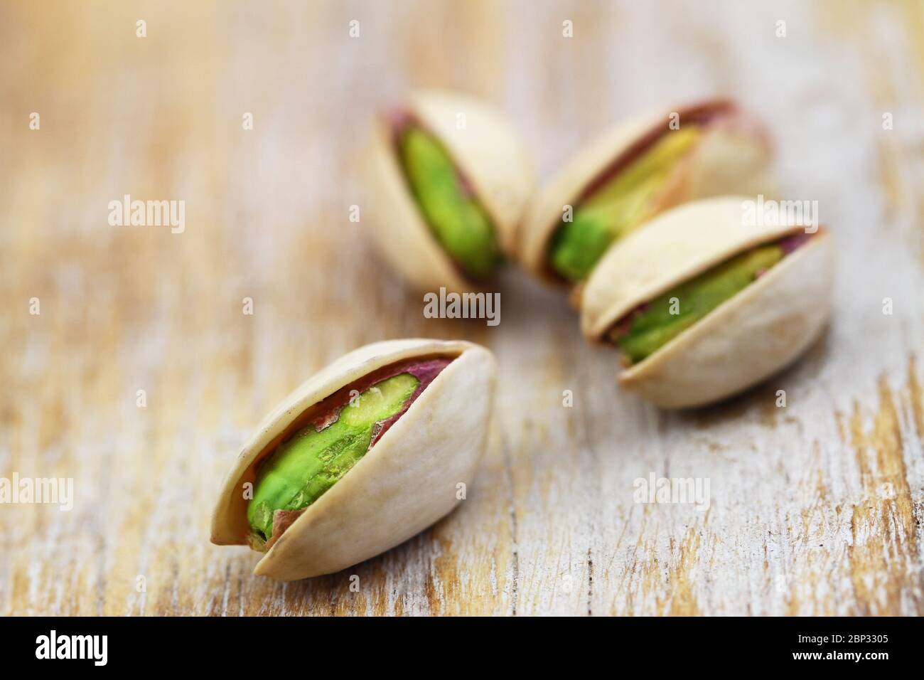 Pochi pistacchi su superficie rustica in legno, chioseup Foto Stock