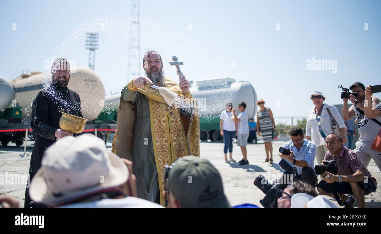 Il 19 luglio 2019, al cosmodromo di Baikonur in Kazakistan, un sacerdote ortodosso benedisse i membri dei media in vista del lancio della Expedition 60 a bordo della Sojuz MS-13, con il comandante di Roscosmos Alexander Skvortsov, l'ingegnere di volo della NASA Drew Morgan e l'ingegnere di volo dell'ESA Luca Parmitano. Foto Stock