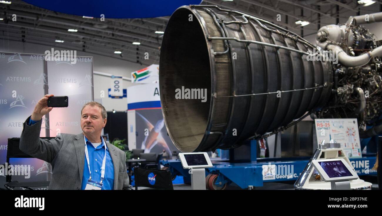 Al 70° Congresso Astronautico Internazionale il 22 ottobre 2019, un partecipante fa un selfie con un motore RS-25, uno dei componenti chiave che alimentano lo Space Launch System della NASA, alla mostra NASA di Washington, D.C. Foto Stock