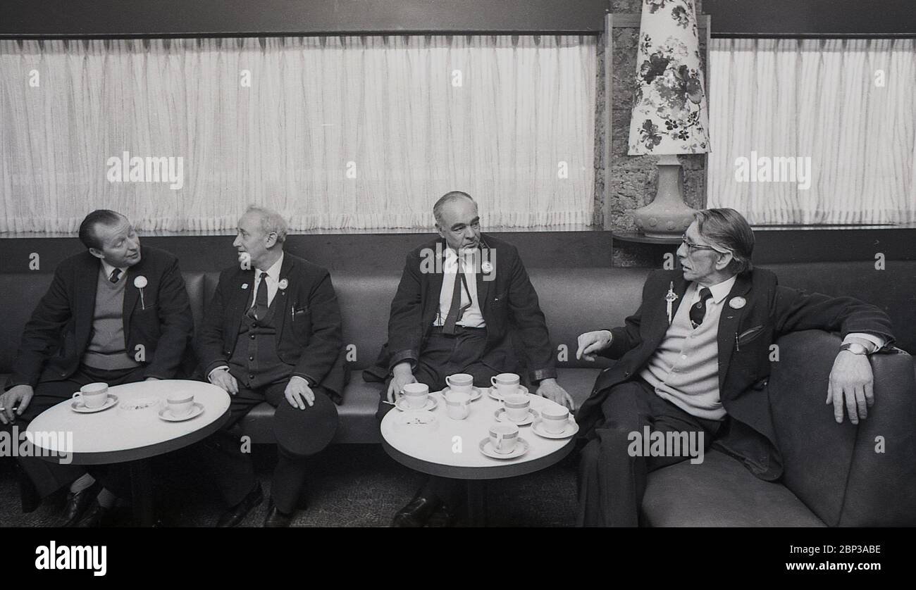 Interno, Bus staff Rest room New Cross, South London, England, 1974, foto mostra quattro membri dell'equipaggio in uniforme che si sono impegnati in una pausa e una chat con una tazza di tè. Foto Stock