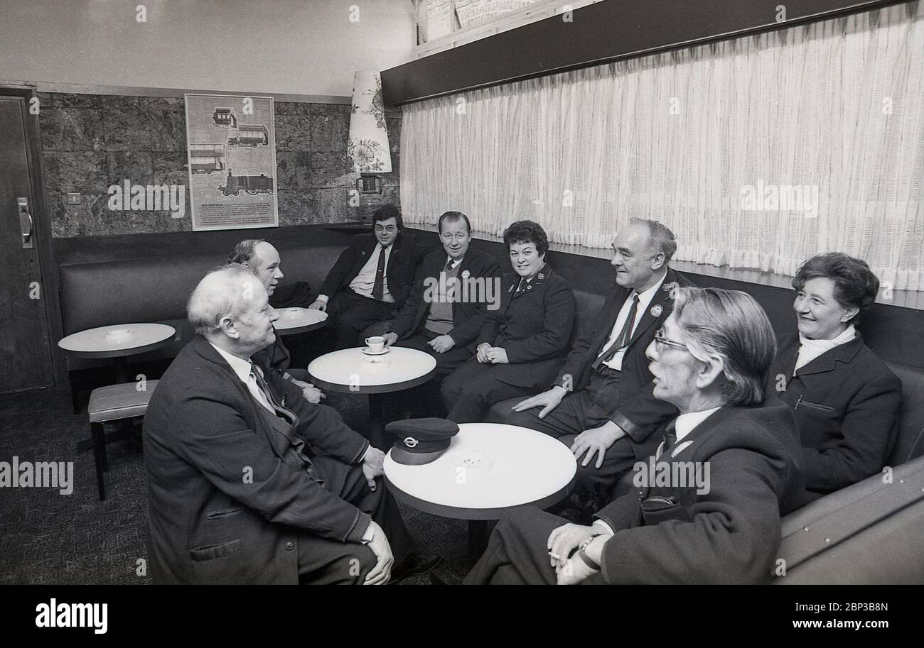 Immagine interna che mostra i lavoratori in uniforme degli autobus seduti insieme in una sala di riposo presso il deposito degli autobus di New Cross, a sud-est di Londra, Inghilterra, 1974. L'equipaggio dell'autobus sta facendo una pausa, una tazza di tè, un fumo e una chiacchierata con i colleghi di lavoro. Originariamente un deposito di tram, New Cross fu convertita in un depoet di autobus n 1952 ed era uno dei più grandi garage di autobus di Londra. Foto Stock