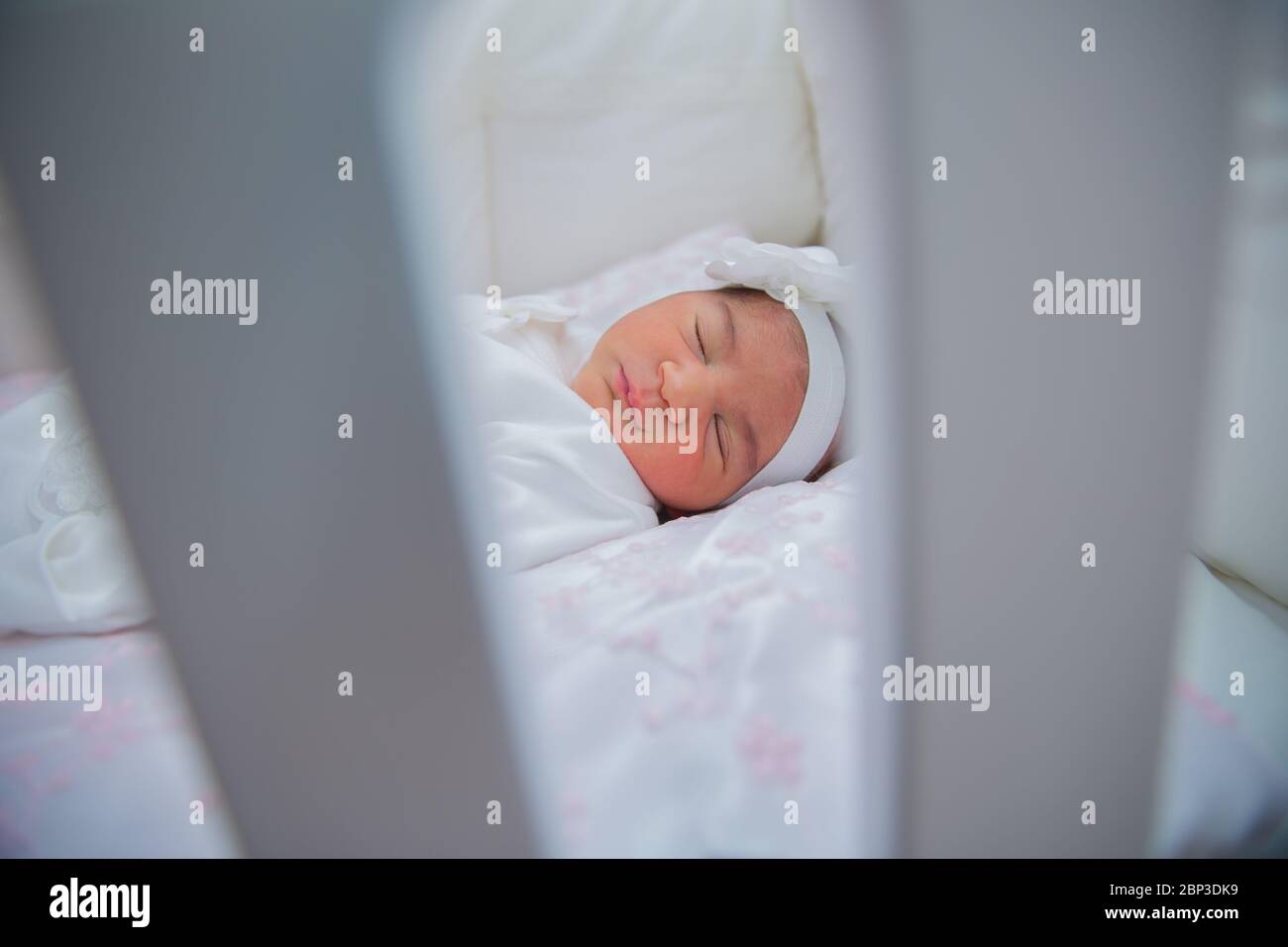 Bella bambina neonato in letto, vedere le barre del lettino per dormire. Adorabile bambina che dorme in culla con divano letto attaccata al letto dei genitori. Il giocattolo di un bambino è Foto Stock