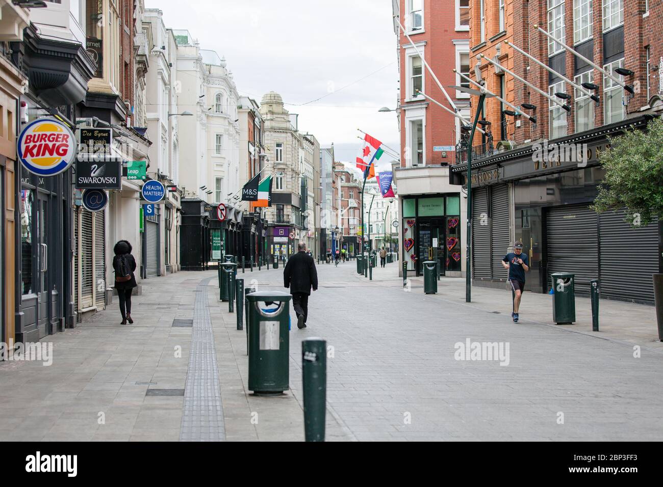 Pedoni su Grafton Street deserta nel centro di Dublino, mentre la caduta dei piedi precipita a causa della pandemia di coronavirus. Covid-19 in Irlanda. Foto Stock