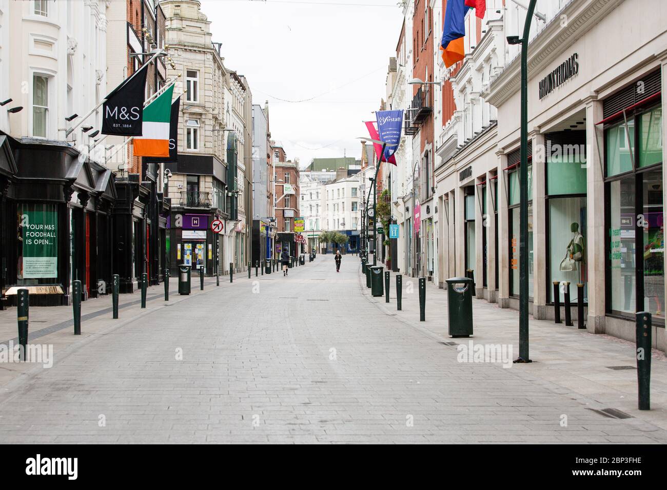 Pedoni su Grafton Street deserta nel centro di Dublino, mentre la caduta dei piedi precipita a causa della pandemia di coronavirus. Covid-19 in Irlanda. Foto Stock