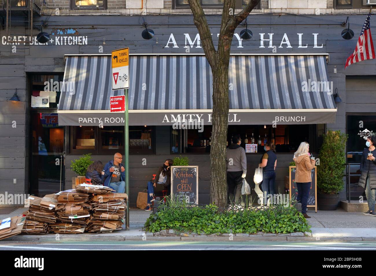 La scena fuori Amity Hall ristorante a New York aperto per affari take-out, e cocktail take-away durante la crisi del coronavirus Foto Stock